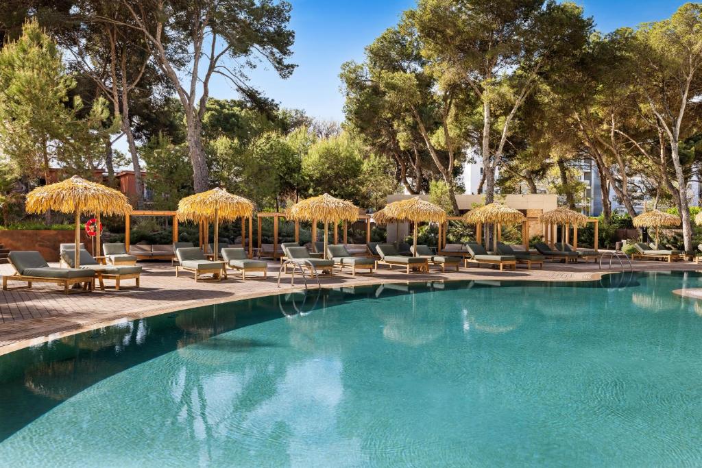 Outdoor swimming pool with sun loungers and shaded cabanas at Aubamar Palma Resort in Playa de Palma, Mallorca.