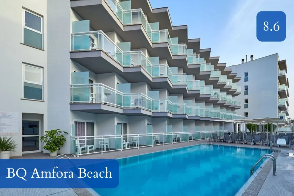 Outdoor swimming pool at BQ Amfora Beach featuring modern hotel buildings with glass balconies, sun loungers, and poolside seating in Can Pastilla, Mallorca