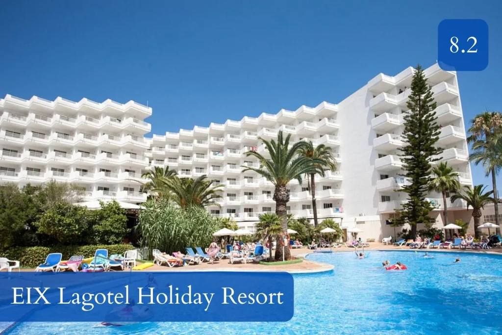 Large outdoor swimming pool surrounded by palm trees, sun loungers, and multi-story resort buildings at EIX Lagotel Holiday Resort in Playa de Muro, Mallorca