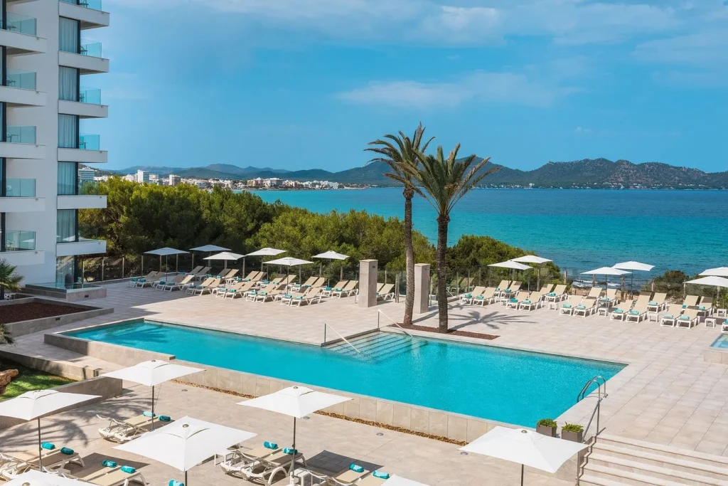 Seafront pool with Mediterranean coastline views at Iberostar Waves Cala Millor in Cala Millor, Mallorca.