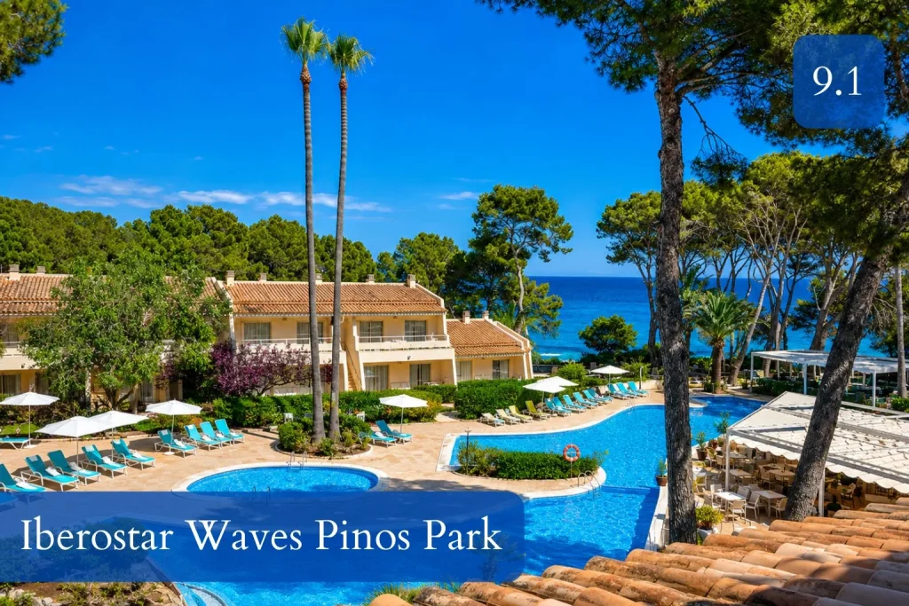 Seafront swimming pool surrounded by pine trees at Iberostar Waves Pinos Park in Mallorca