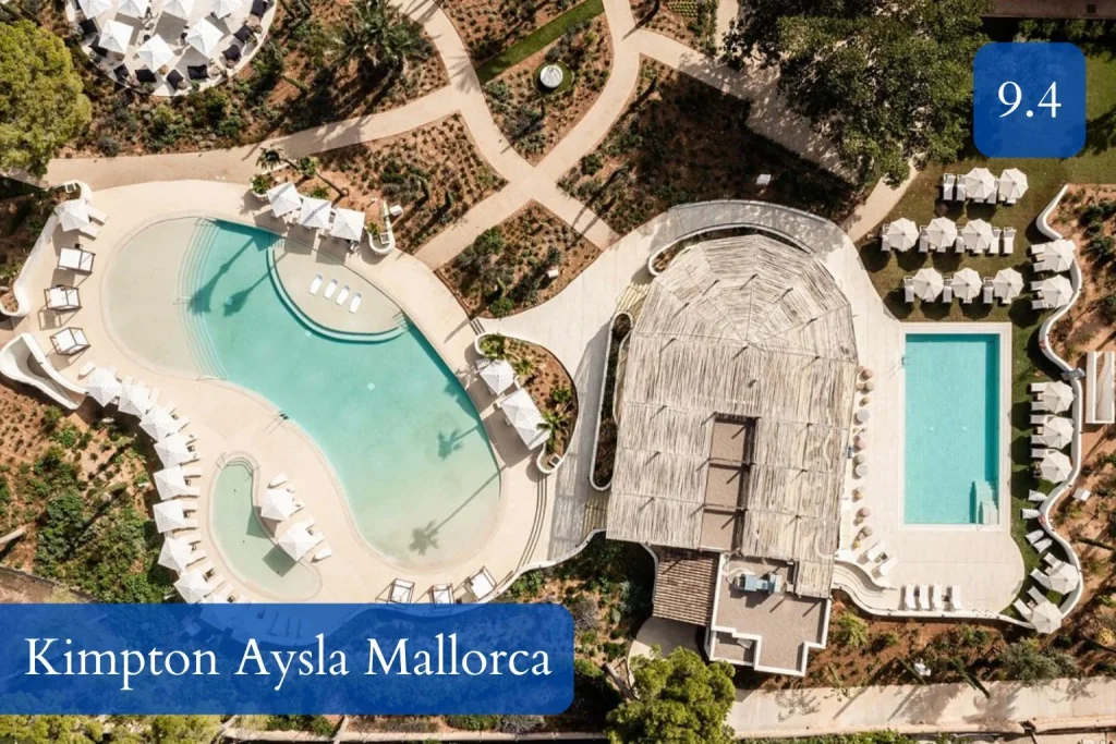 Aerial view of outdoor pools, sun loungers, and landscaped gardens at Kimpton Aysla Mallorca in Santa Ponça, Mallorca