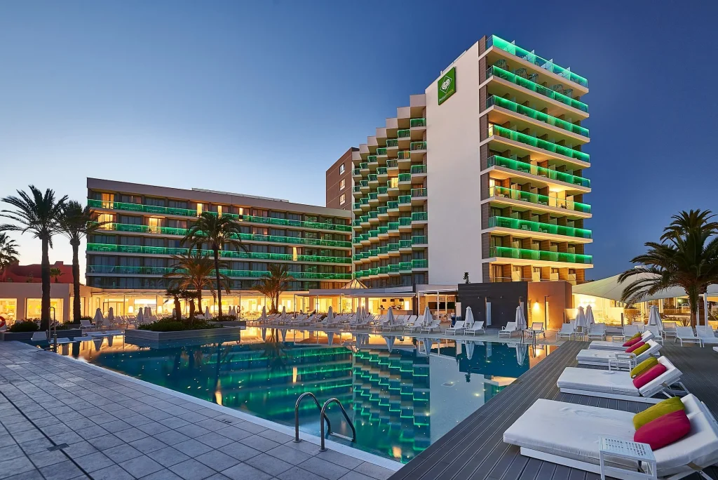 Main pool and illuminated hotel at dusk at Protur Playa Cala Millor in Cala Millor, Mallorca.