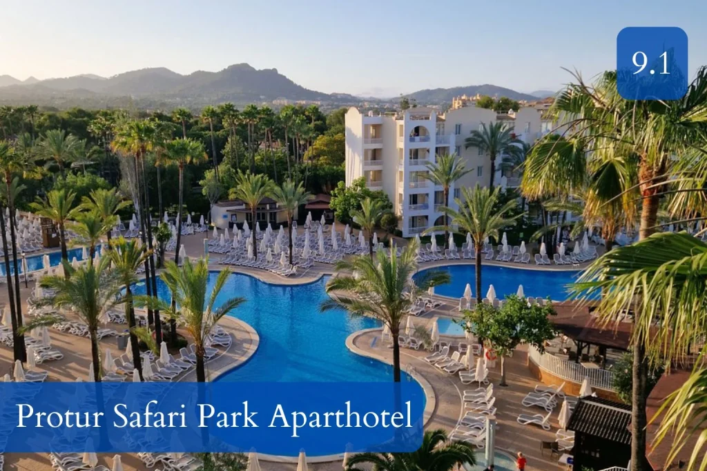 Large lagoon-style swimming pool surrounded by palm trees at Protur Safari Park Aparthotel in Mallorca