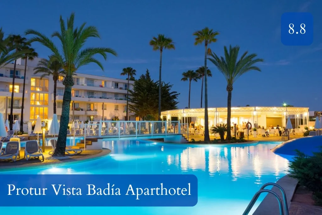 Illuminated lagoon-style pool at Protur Vista Badía Aparthotel in Sa Coma, Mallorca at dusk