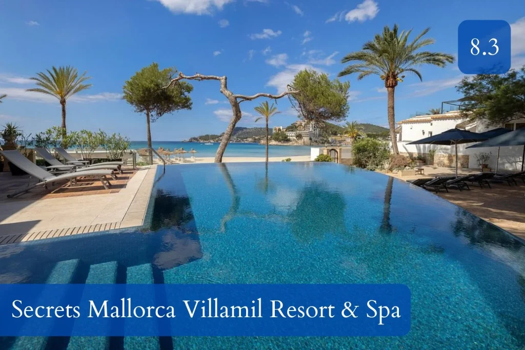 Infinity pool overlooking the Mediterranean Sea at Secrets Mallorca Villamil Resort & Spa in Peguera, featuring palm trees, sun loungers, and direct views of the beachfront under a clear blue sky.