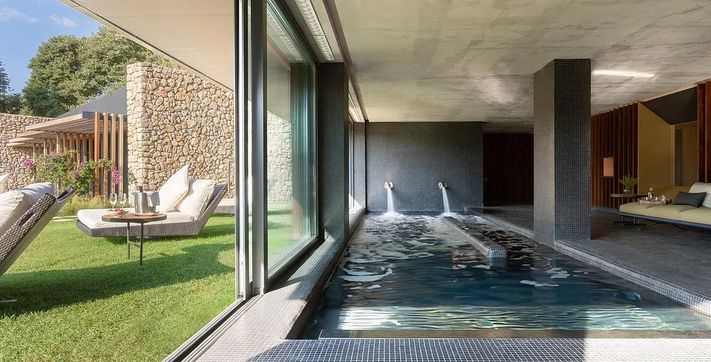 Indoor spa hydrotherapy pool with garden terrace at Son Brull Hotel & Spa in Pollença, Mallorca.