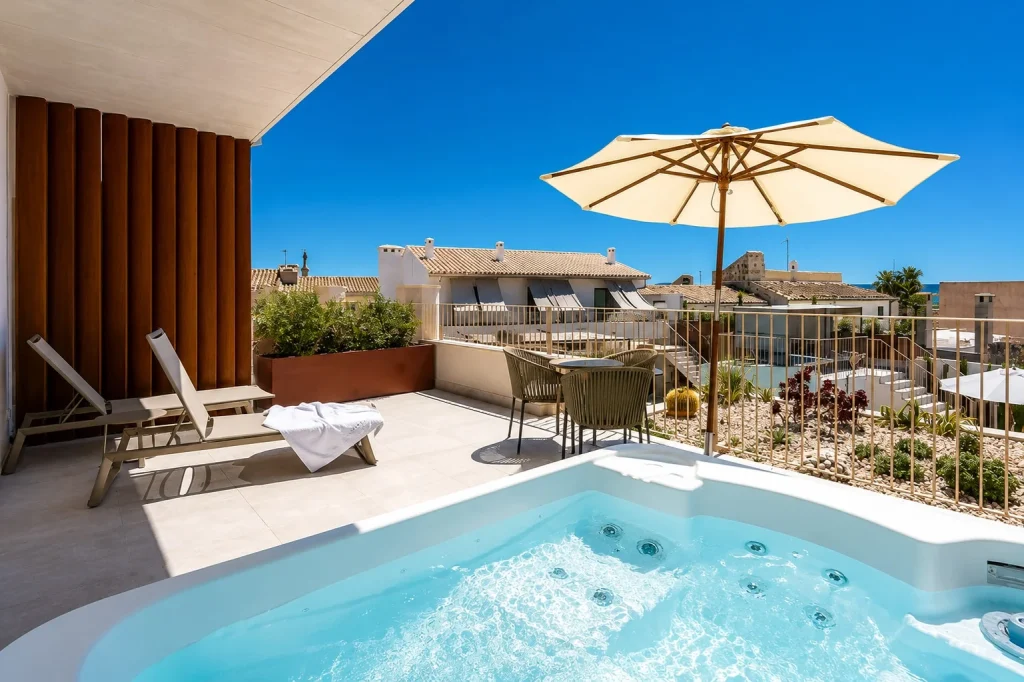 Private suite terrace with an outdoor jacuzzi, sun loungers, and seating area at Ynaira Hotel & Spa in Ariany, Mallorca.