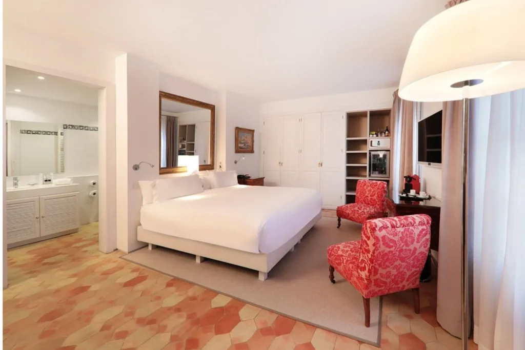 Deluxe hotel room with king-size bed, seating area, and open bathroom at AH Art Hotel Palma in Palma de Mallorca