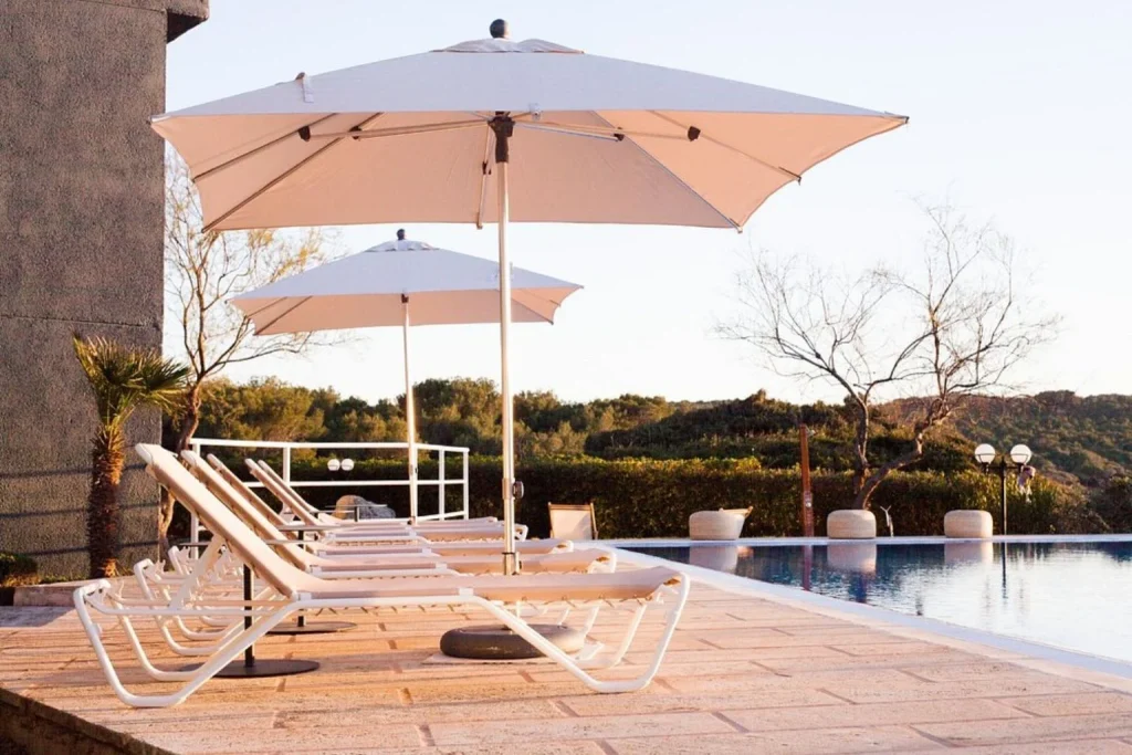 Outdoor swimming pool with sun loungers and parasols at Aparthotel Sa Punta de s'Estanyol in Colònia de Sant Pere, Mallorca.