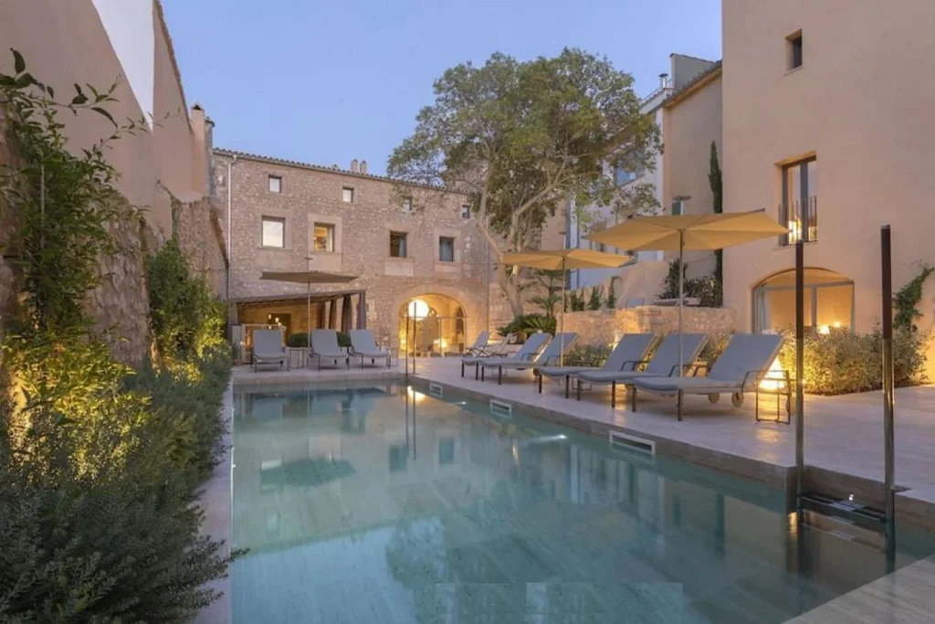 Elegant courtyard pool framed by restored stone architecture at Can Aulí Luxury Retreat in Pollença Town.