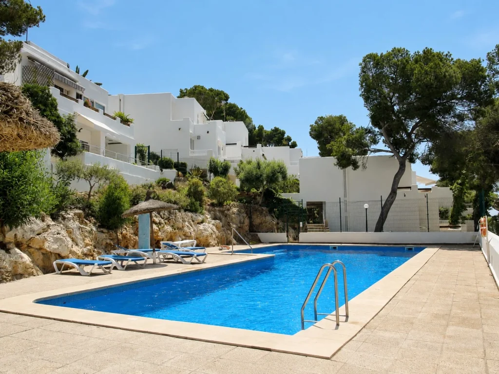 Outdoor swimming pool with sun loungers at Casa Cala d'Or in Cala d'Or, Mallorca.