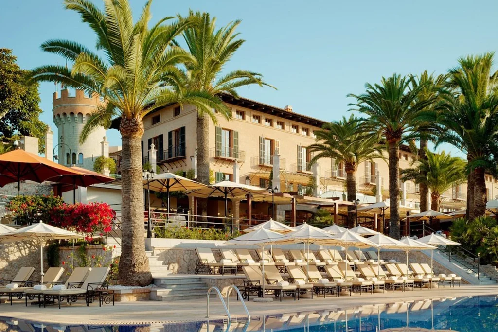 Outdoor pool lined with palm trees at Castillo Hotel Son Vida in Palma, Mallorca.