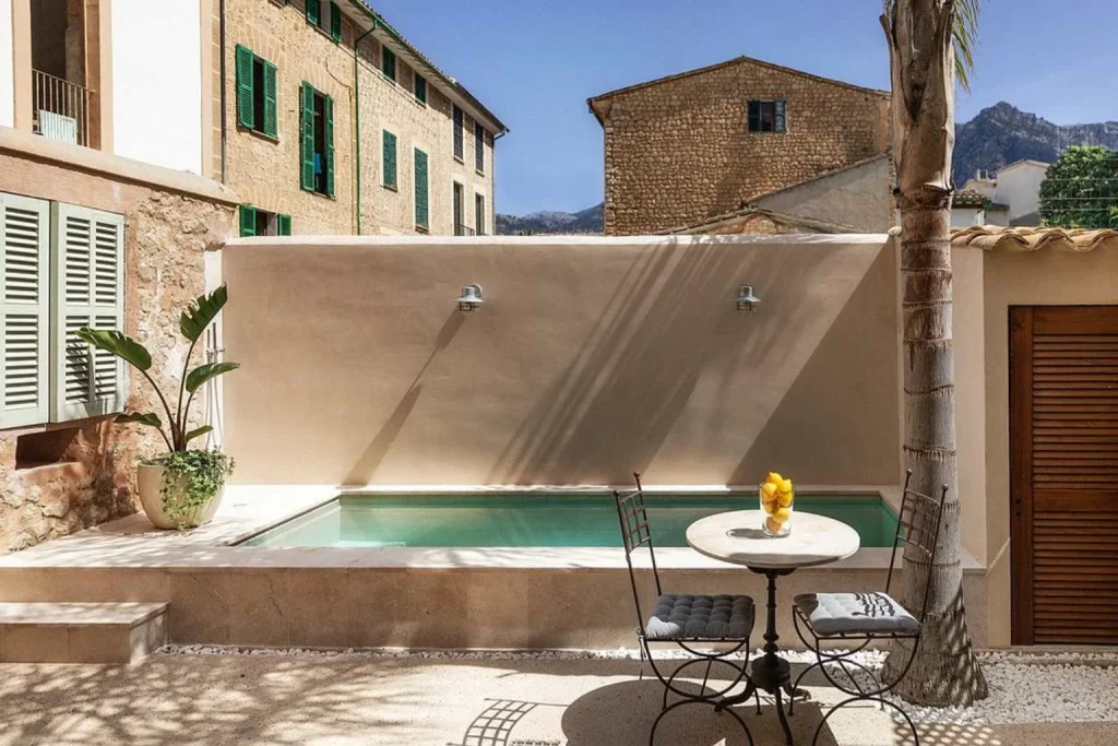 Private outdoor plunge pool with a courtyard terrace at Ecocirer in Sóller Town, surrounded by traditional stone buildings and Mediterranean architecture.