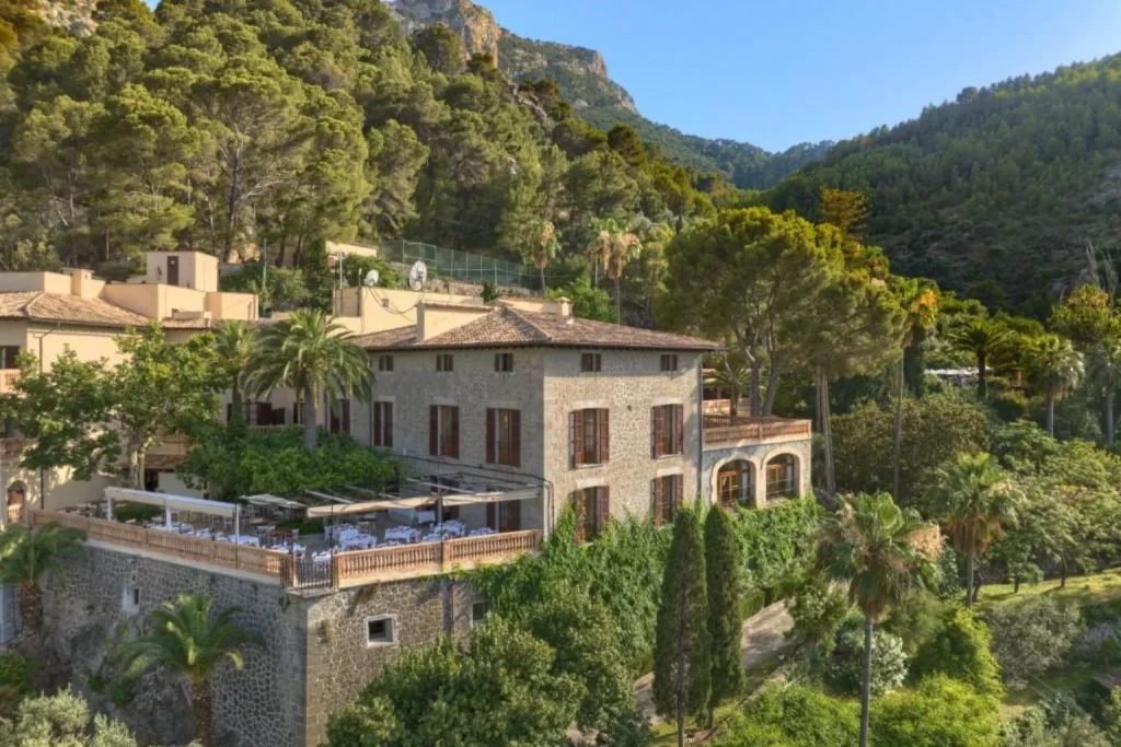 Hotel building surrounded by gardens with views of the Tramuntana mountains at Es Molí Hotel in Deià, Mallorca.