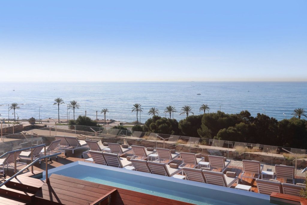 Rooftop infinity pool with sun loungers and panoramic Mediterranean Sea views at Es Princep in Palma, Mallorca