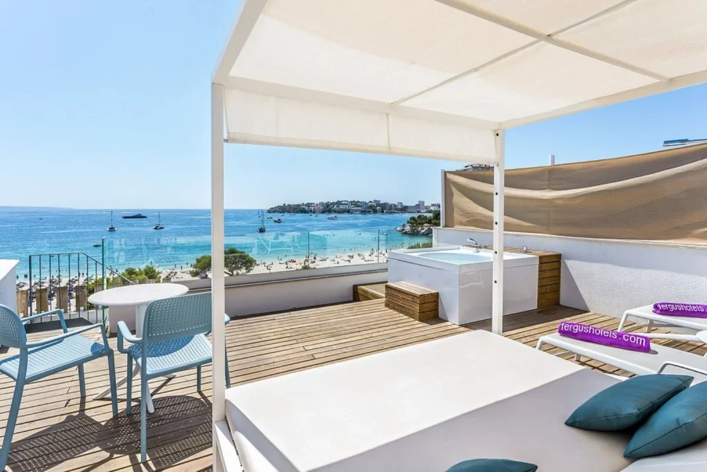 Sea-view suite terrace with outdoor hot tub at FERGUS Style Palmanova in Palmanova, Majorca.