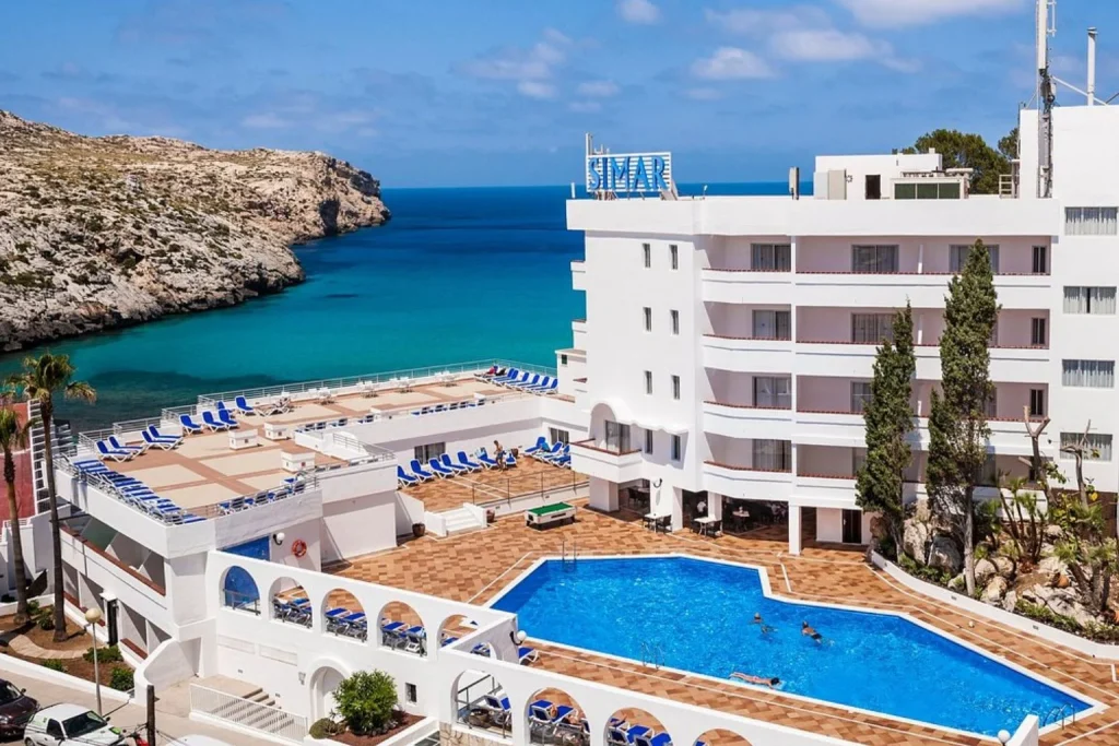 Outdoor swimming pool with seafront view at Globales Simar in Cala Sant Vicenç, Mallorca.
