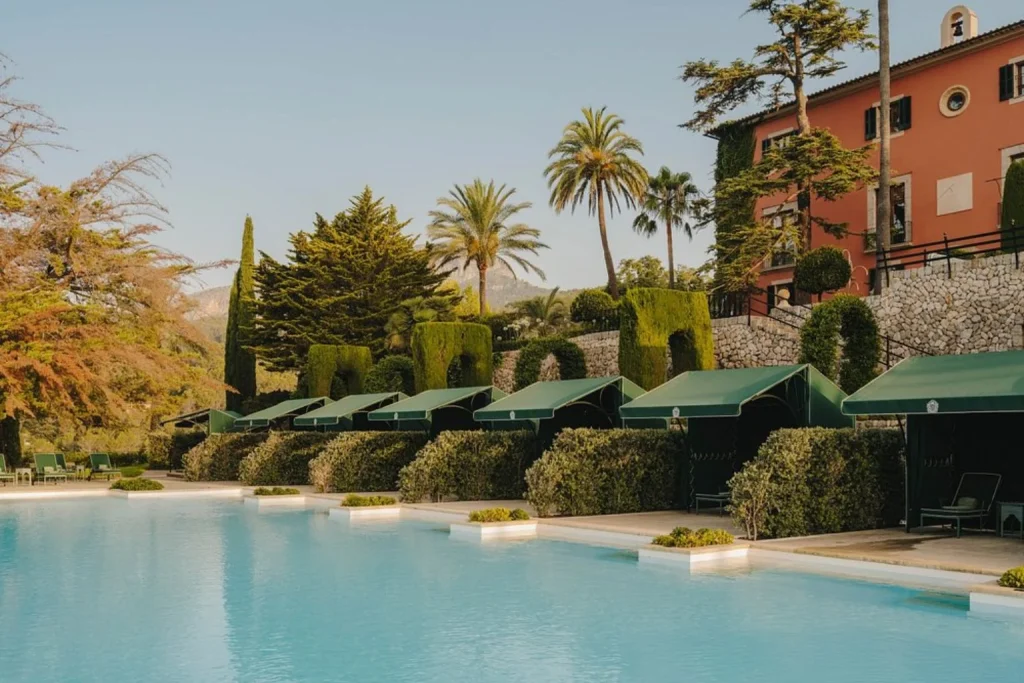 Outdoor swimming pool with private cabanas and landscaped gardens at Gran Hotel Son Net in Puigpunyent.