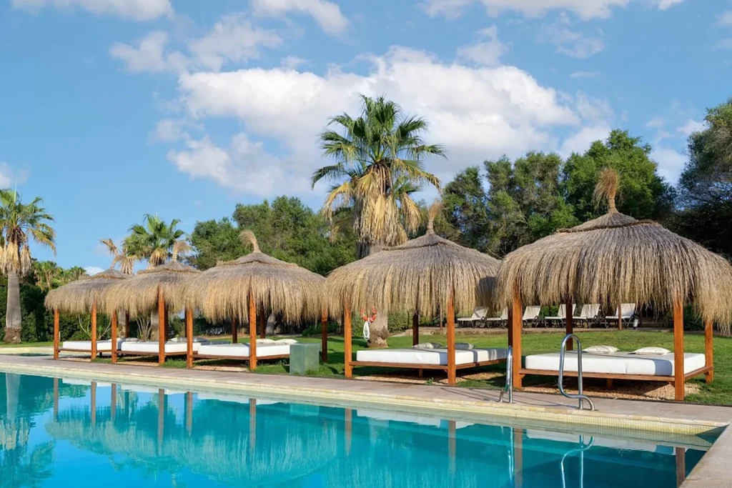 Poolside cabanas surrounded by palm trees at Hacienda Son Antem Golf Resort in Llucmajor, Mallorca.