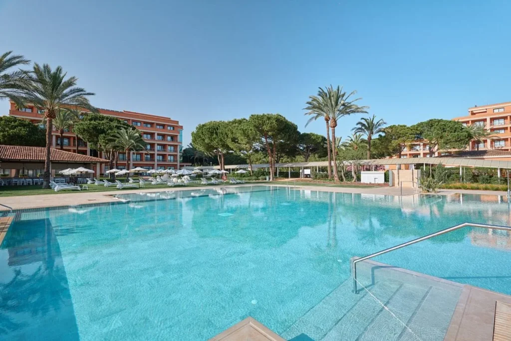 Outdoor pool surrounded by gardens at Hipotels Hipocampo Palace & Spa in Cala Millor, Majorca.