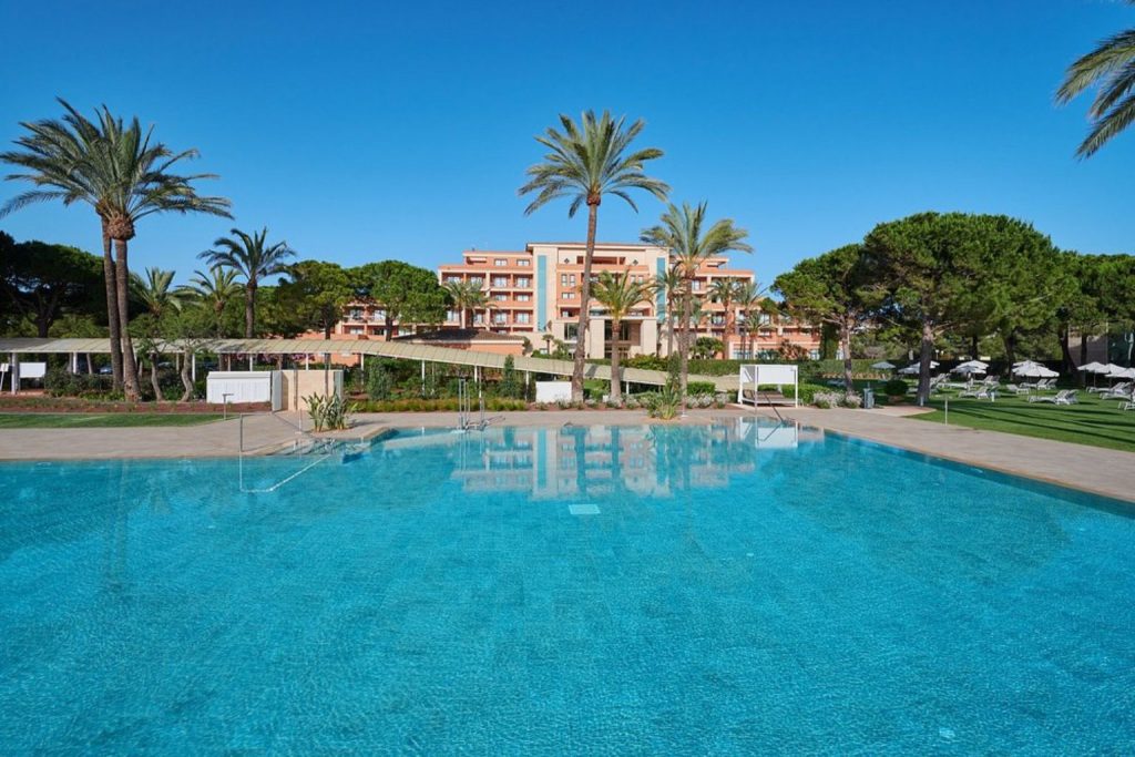 Outdoor pool with palm trees at Hipotels Hipocampo Palace & Spa in Sa Coma, Mallorca