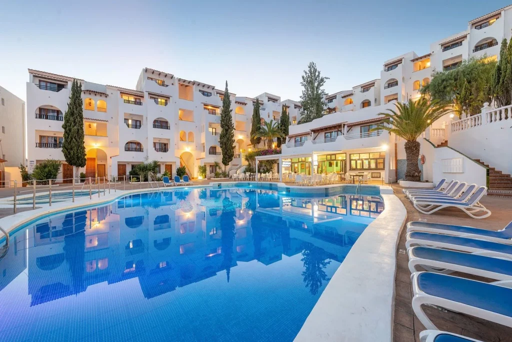 Large outdoor swimming pool surrounded by apartment buildings at Holiday Park Apartments near Santa Ponsa, Majorca.