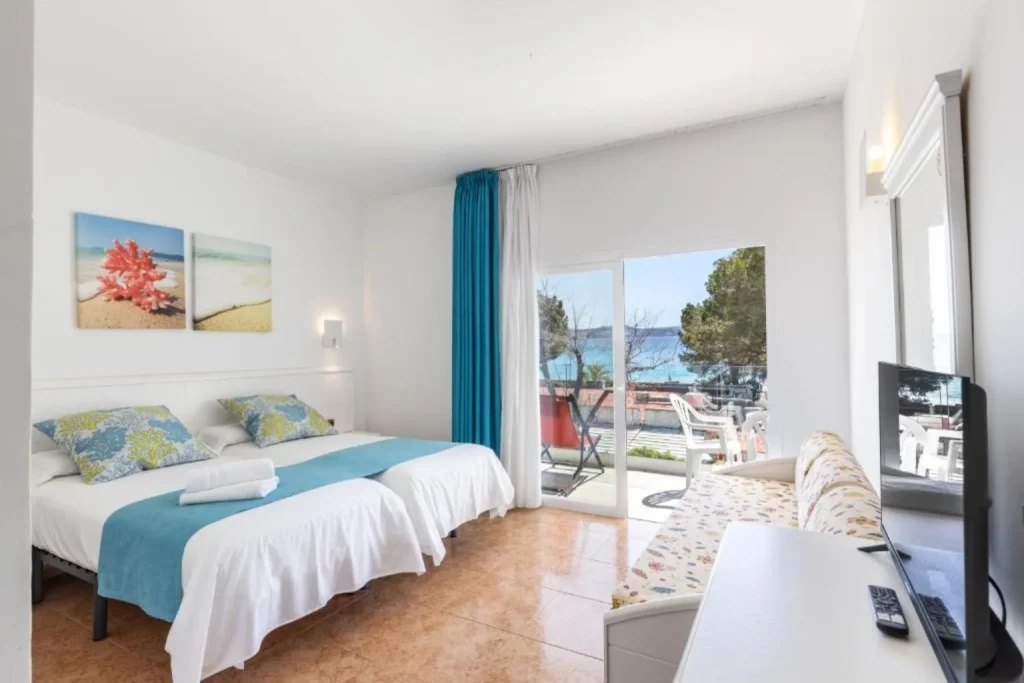 Guest room with balcony and sea views at Hostal Neptuno in Peguera, Majorca.