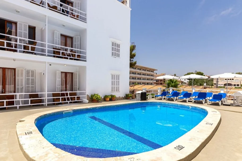Outdoor swimming pool with sun loungers at Hostal San Francisco in Cala d'Or, Mallorca.