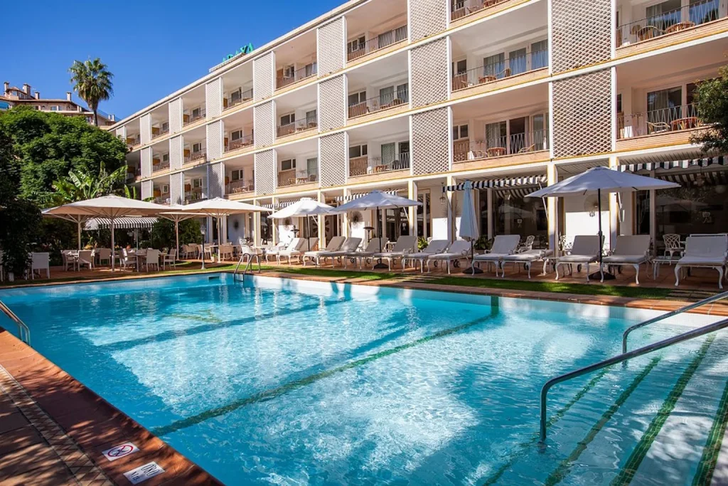 Outdoor pool with sun loungers at Hotel Araxa in Palma, Mallorca