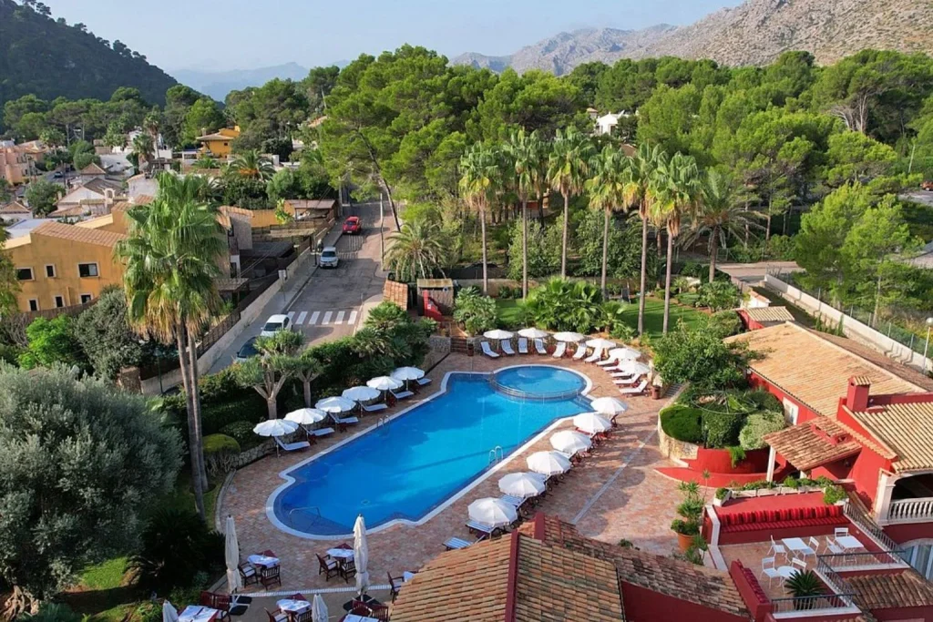 Outdoor swimming pool with loungers and mountain view at Hotel Cala Sant Vicenç in Cala Sant Vicenç, Mallorca