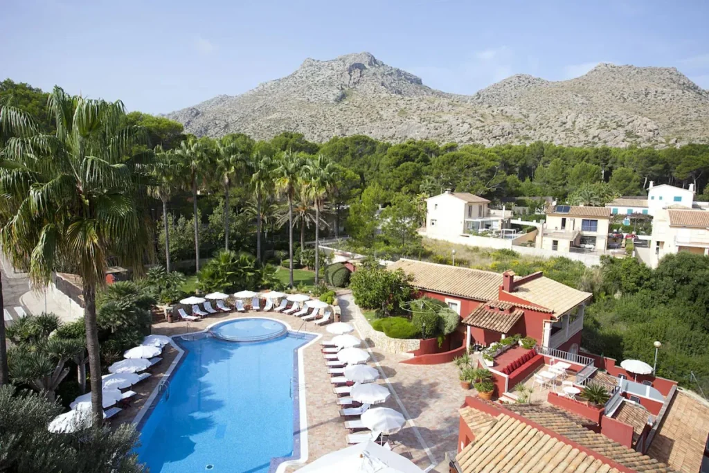 Swimming pool with sun loungers and mountain view at Hotel Cala Sant Vicenç in Cala Sant Vicenç, Mallorca.