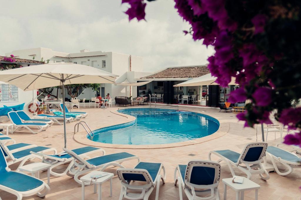 Outdoor swimming pool with sun loungers and parasols at Hotel d'Or in Cala d'Or, Mallorca.