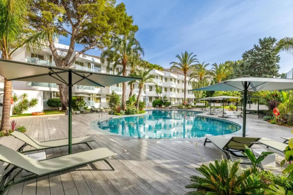 Outdoor pool with sun loungers at Hotel Illa D'Or in Port de Pollença, Mallorca.