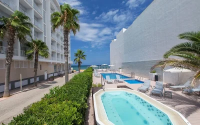 Outdoor hot tub and swimming pool with sea view at Hotel JS Miramar in Can Picafort, Mallorca.
