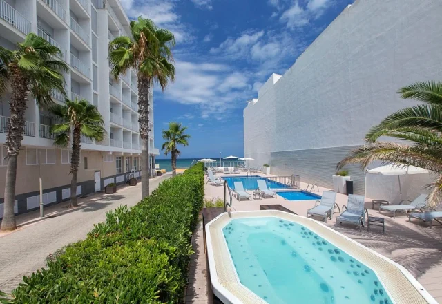 Outdoor hot tub and swimming pool with sea view at Hotel JS Miramar in Can Picafort, Mallorca.