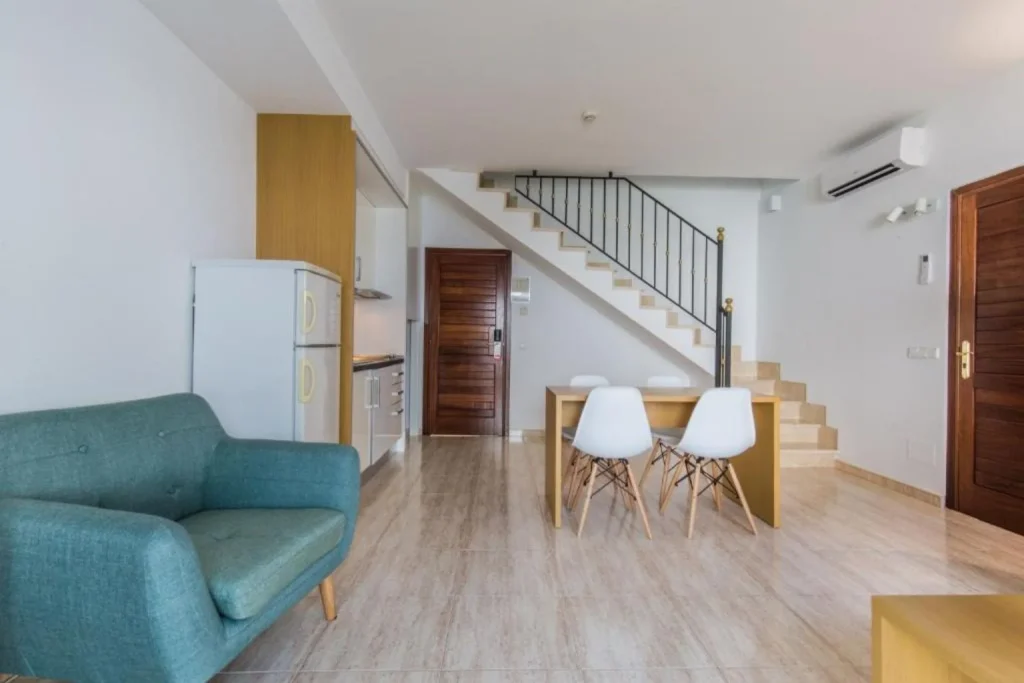 Duplex apartment with a kitchenette, dining area, and staircase at Hotel La Pergola Mallorca in Port d'Andratx, Mallorca.