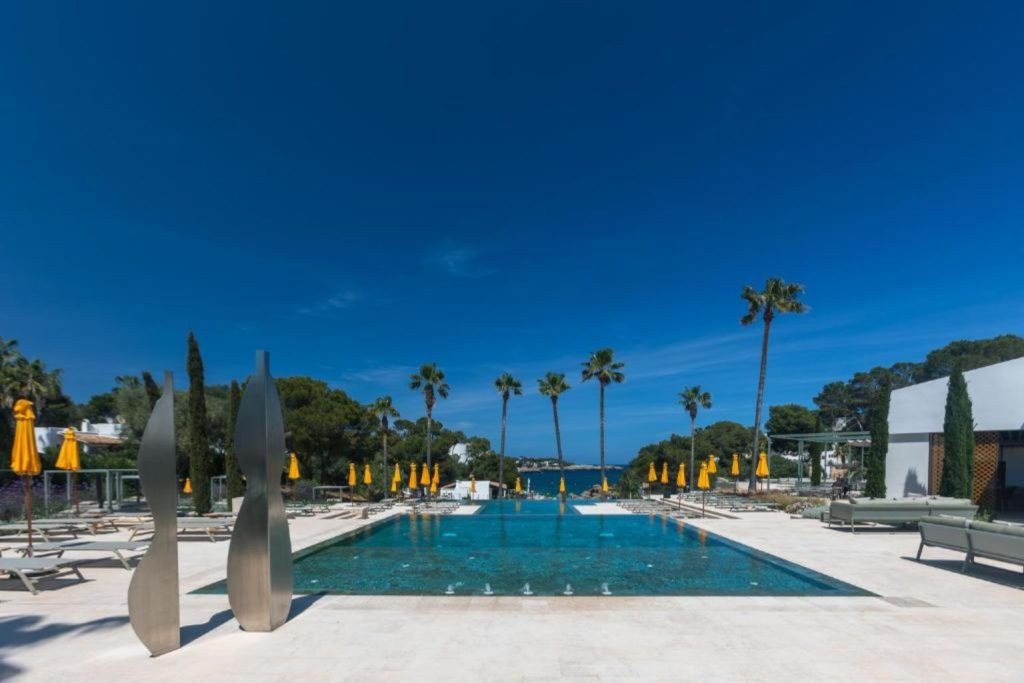 Main outdoor swimming pool with Mediterranean Sea views at Hotel Rocamarina – Adults Only in Cala d'Or, Mallorca.