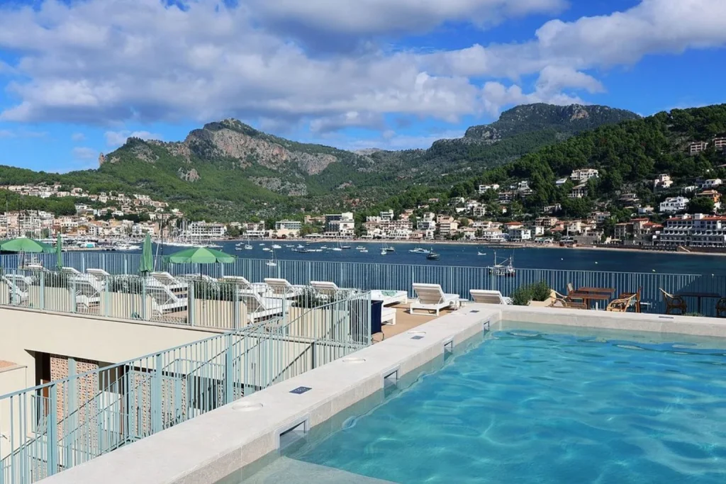 Rooftop swimming pool with views of Port de Sóller Bay, the marina, and surrounding mountains at Hotel Salino Port in Port de Sóller, Mallorca
