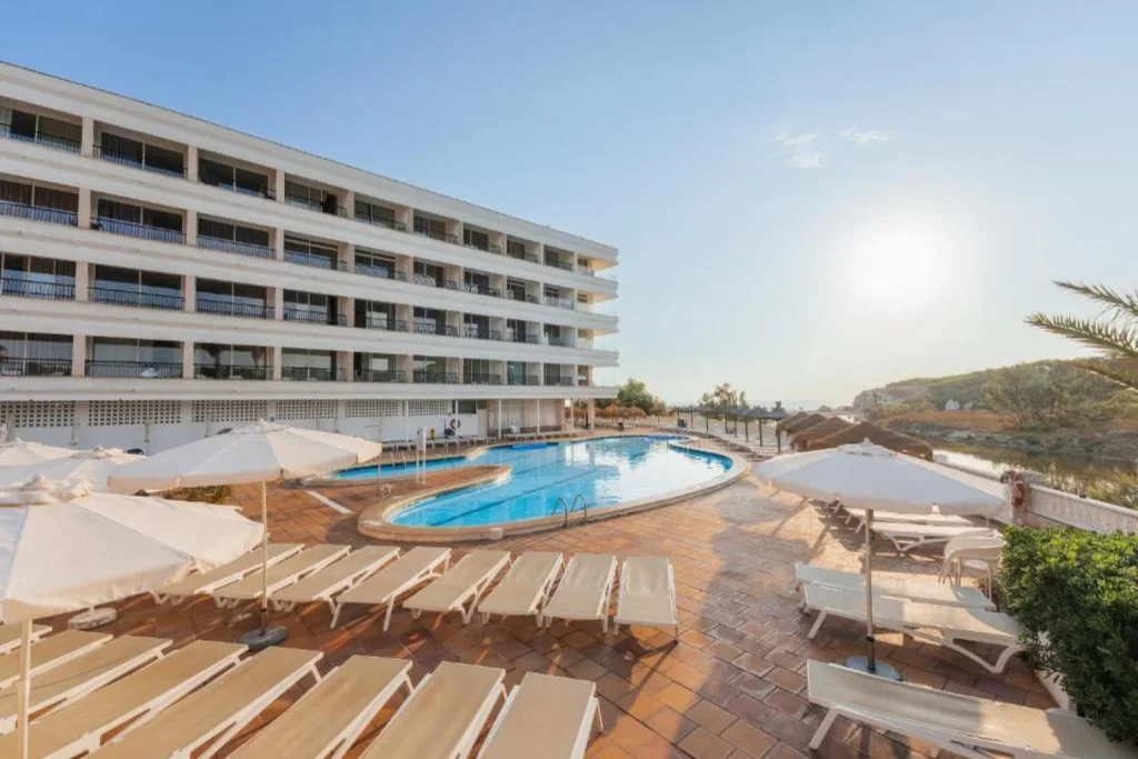 Outdoor swimming pool with sun loungers at Hotel Son Baulo in Can Picafort, Mallorca.