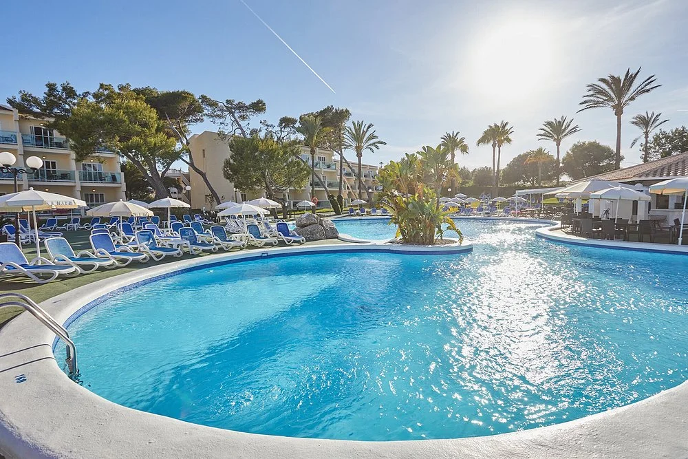 Outdoor swimming pool with sun loungers at Hotel Stil Picafort Park in Can Picafort, Mallorca.