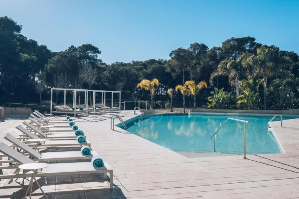 Outdoor swimming pool with sun loungers and landscaped gardens at Iberostar Selection Llaut Palma in Playa de Palma, Mallorca.