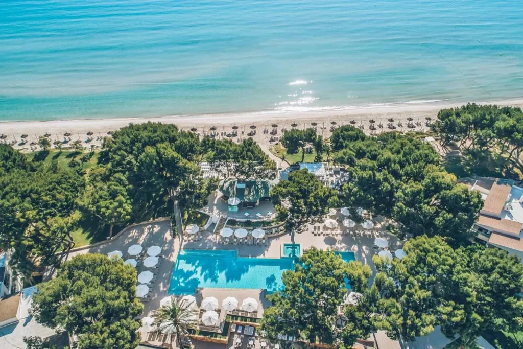 Aerial view of the beachfront pools and Mediterranean coastline at Iberostar Selection Playa de Muro Village in Playa de Muro, Majorca.