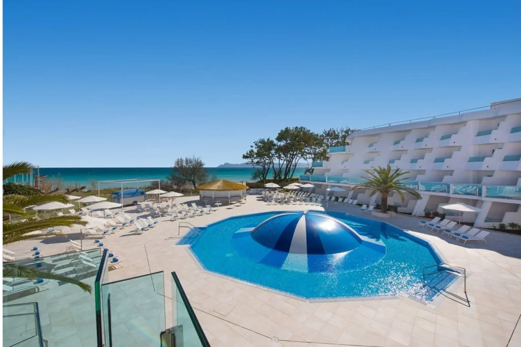 Outdoor swimming pool by the beach at Iberostar Waves Playa de Muro in Playa de Muro, Mallorca.