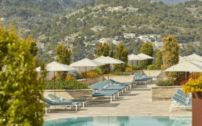 Infinity pool with sun loungers, parasols, and Tramuntana mountain views at Jumeirah Mallorca in Port de Sóller.