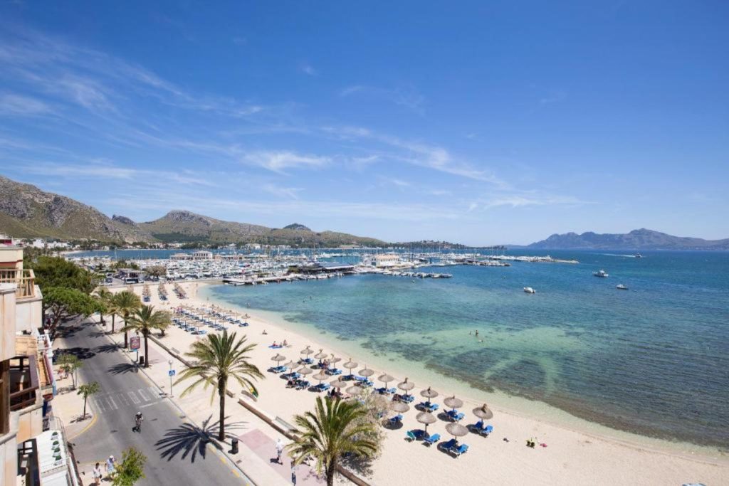 Beachfront view from La Goleta Hotel de Mar overlooking Puerto Pollensa Beach and the marina in Majorca.