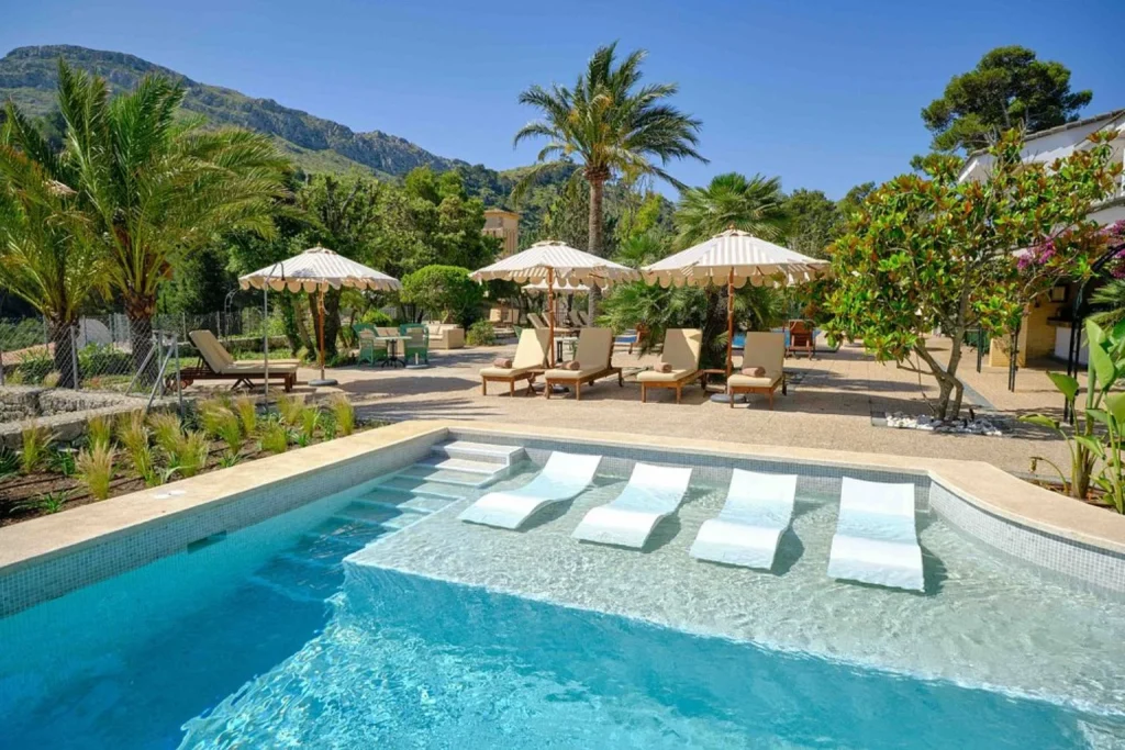 Swimming pool with loungers and mountain view at La Moraleja in Cala Sant Vicenç, Mallorca