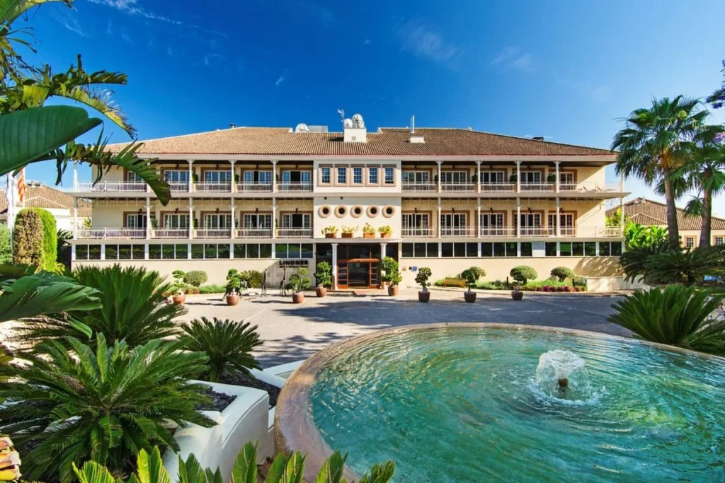 Front entrance with landscaped gardens and fountain in Lindner Hotel Mallorca, Portals Nous, Mallorca, Spain.