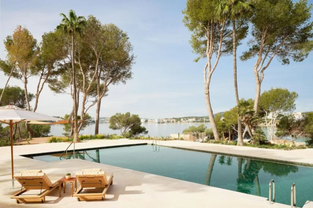 Seafront infinity pool surrounded by pine trees with tranquil bay views at Mandarin Oriental Punta Negra in Calvià.