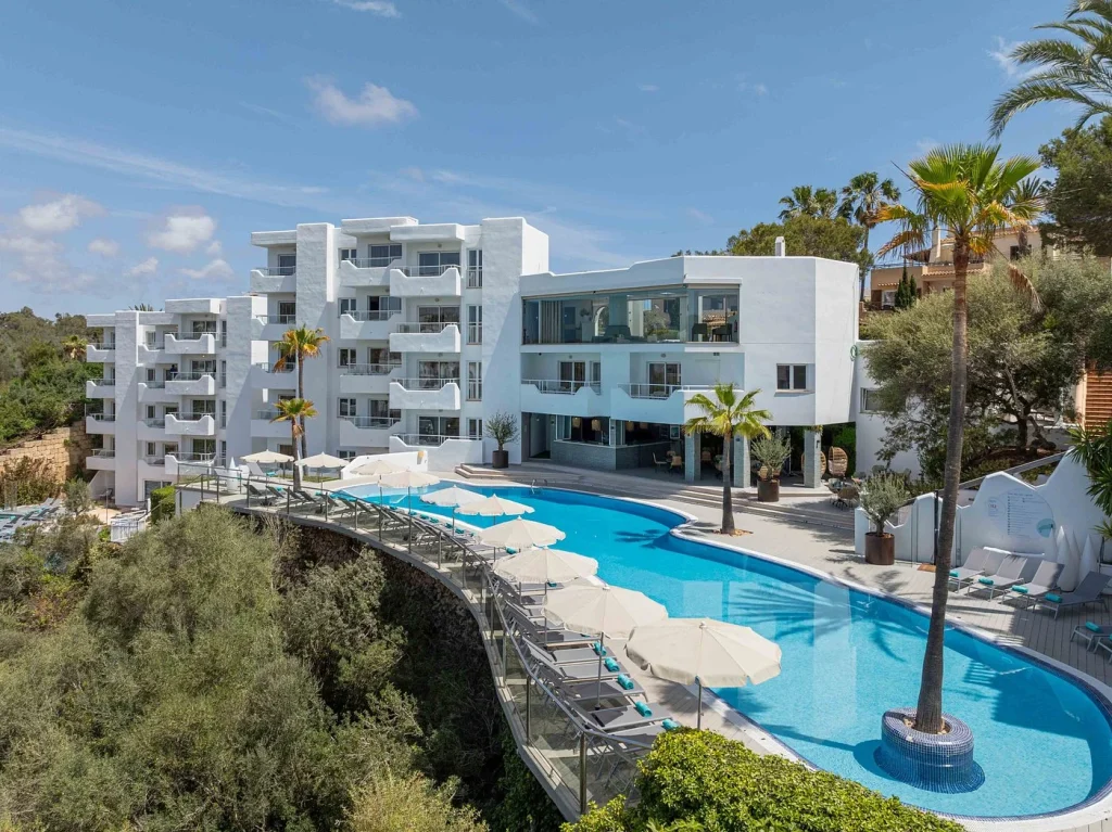 Infinity pool and modern white hotel building at MarSenses Natura Olea Hotel – Adults Only in Cala d'Or, Mallorca.